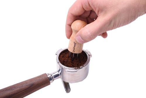 Hand mit Espresso Verteilers (Espresso Distribution Tool) und Siebträger